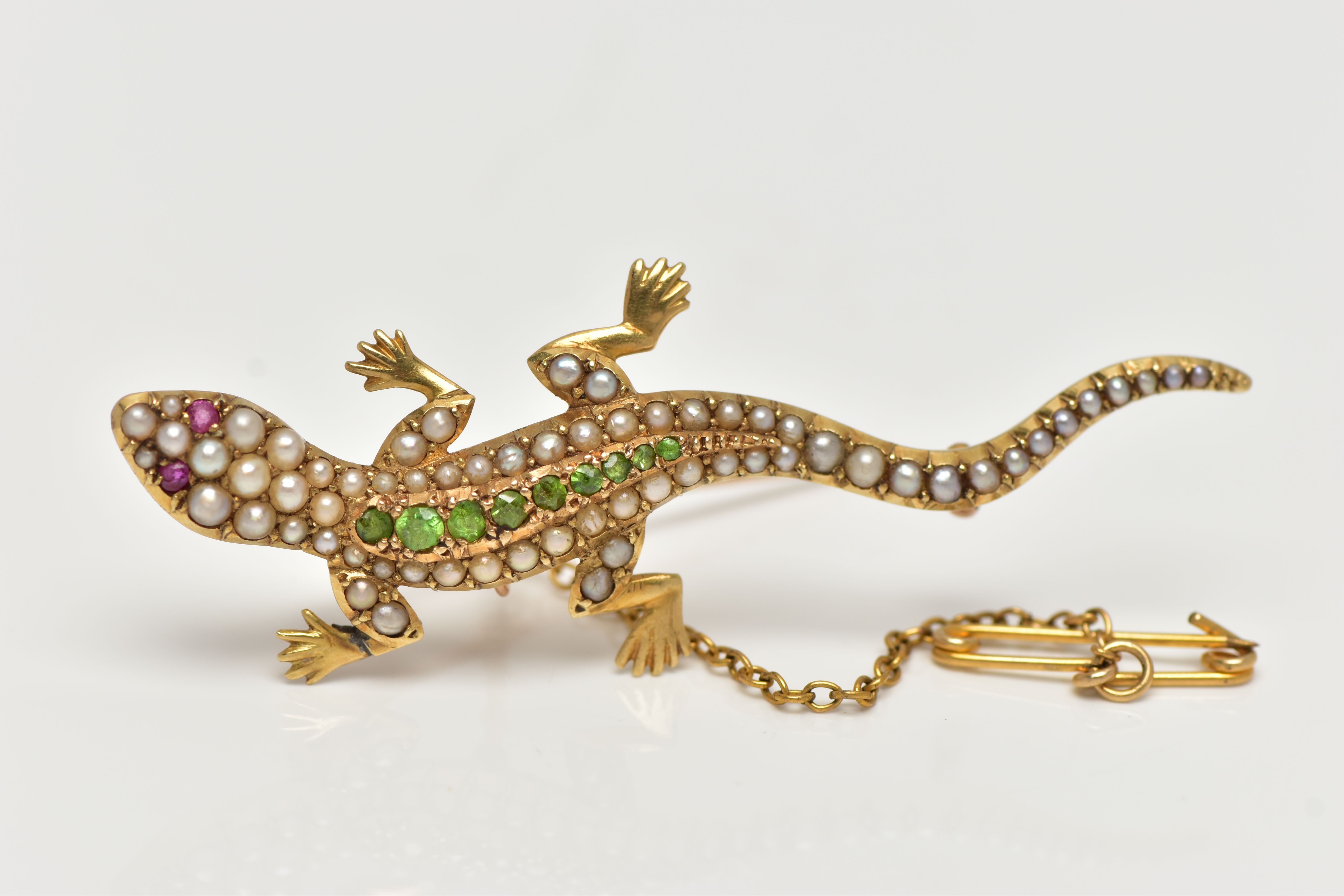 AN EARLY 20TH CENTURY GOLD SALAMANDER BROOCH, set with a row of graduating demaintoid garnets to the