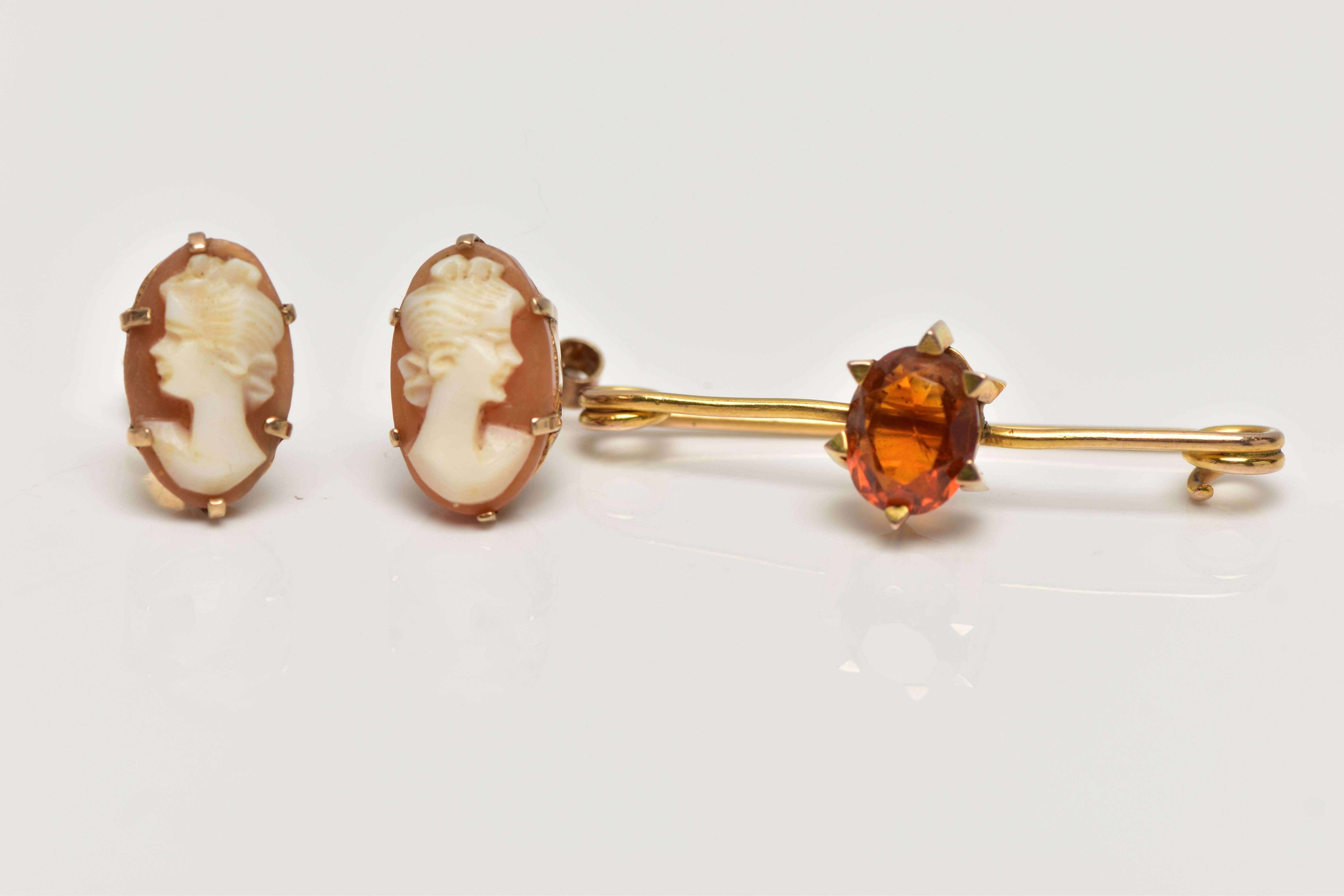 A CITRINE BROOCH AND A PAIR OF CAMEO EARRINGS, the brooch claw set with an oval cut citrine, to