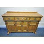 AN OLD CHARM OAK SIDEBOARD, with three drawers, over four cupboard doors, width 153cm x depth 48cm x