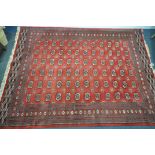 A LARGE 20TH CENTURY RED GROUND TEKKE RUG, 367cm x 278cm