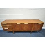 A MCINTOSH TEAK SIDEBOARD, with three drawers and a fall front door, enclosing a white Formica