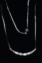 A 9CT GOLD, TOPAZ NECKLACE, a solid white gold crecent shaped bar, set with four emerald cut blue