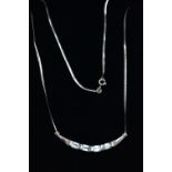 A 9CT GOLD, TOPAZ NECKLACE, a solid white gold crecent shaped bar, set with four emerald cut blue
