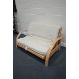 A MODERN BEECH FOLDING FUTON, length 141cm