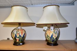 A PAIR OF MOORCROFT POTTERY 'WINDRUSH IRIS' TABLE LAMPS, of baluster form on wooden bases, decorated