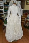 A VINTAGE WEDDING DRESS, ivory 1950s style, long sleeves with tapered cuffs, high neck, ribbon