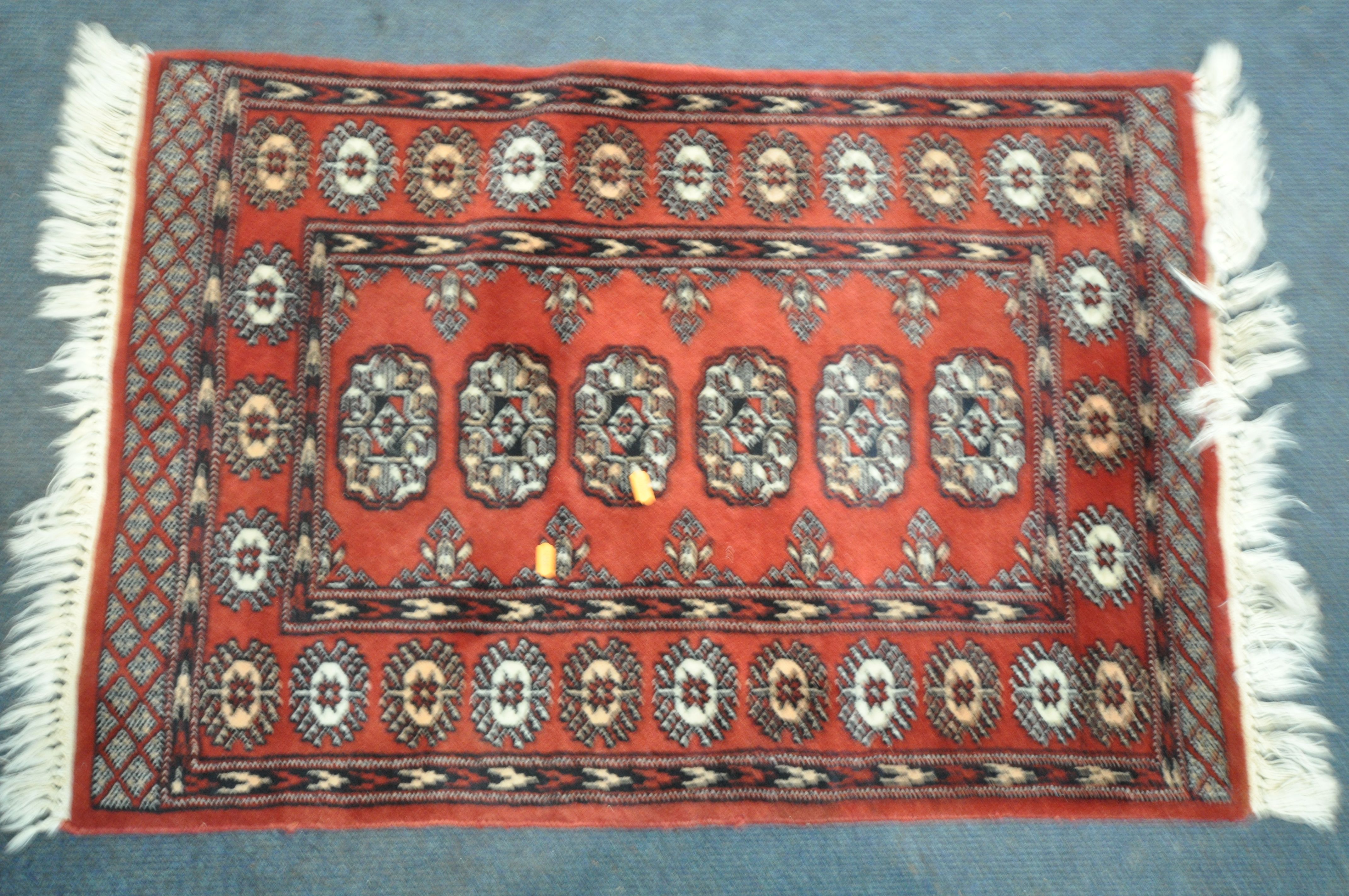 A 20TH CENTURY RED GROUND TEKKE CARPET RUNNER, length 302cm x 82cm, and a pair of red ground tekke - Image 4 of 5