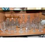 A GROUP OF CUT CRYSTAL GLASS WARES, comprising a tantalus containing three non-matching decanters (