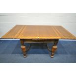 AN EARLY 20TH CENTURY OAK DRAW LEAF DINING TABLE, on acorn legs, united by a shaped stretcher,