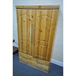 A MODERN PINE DOUBLE DOOR WARDROBE, with two drawers, width 107cm x depth 57cm x height 181cm (