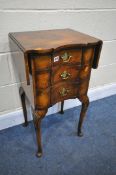 A REPRODUCTION WALNUT DROP LEAF LAMP TABLE, with three drawers, on cabriole legs, open width 71cm