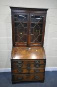 A GEORGIAN AND LATER OAK BUREAU BOOKCASE, the later top, enclosing three adjustable shelves, over