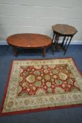 AN EDWARDIAN WALNUT OCTAGONAL CENTRE TABLE, a Cherrywood oval coffee table, and a floral rug (3)