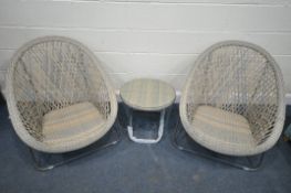 A FAUX RATTAN BISTRO SET, comprising a pair of folding egg chairs and circular table with a glass