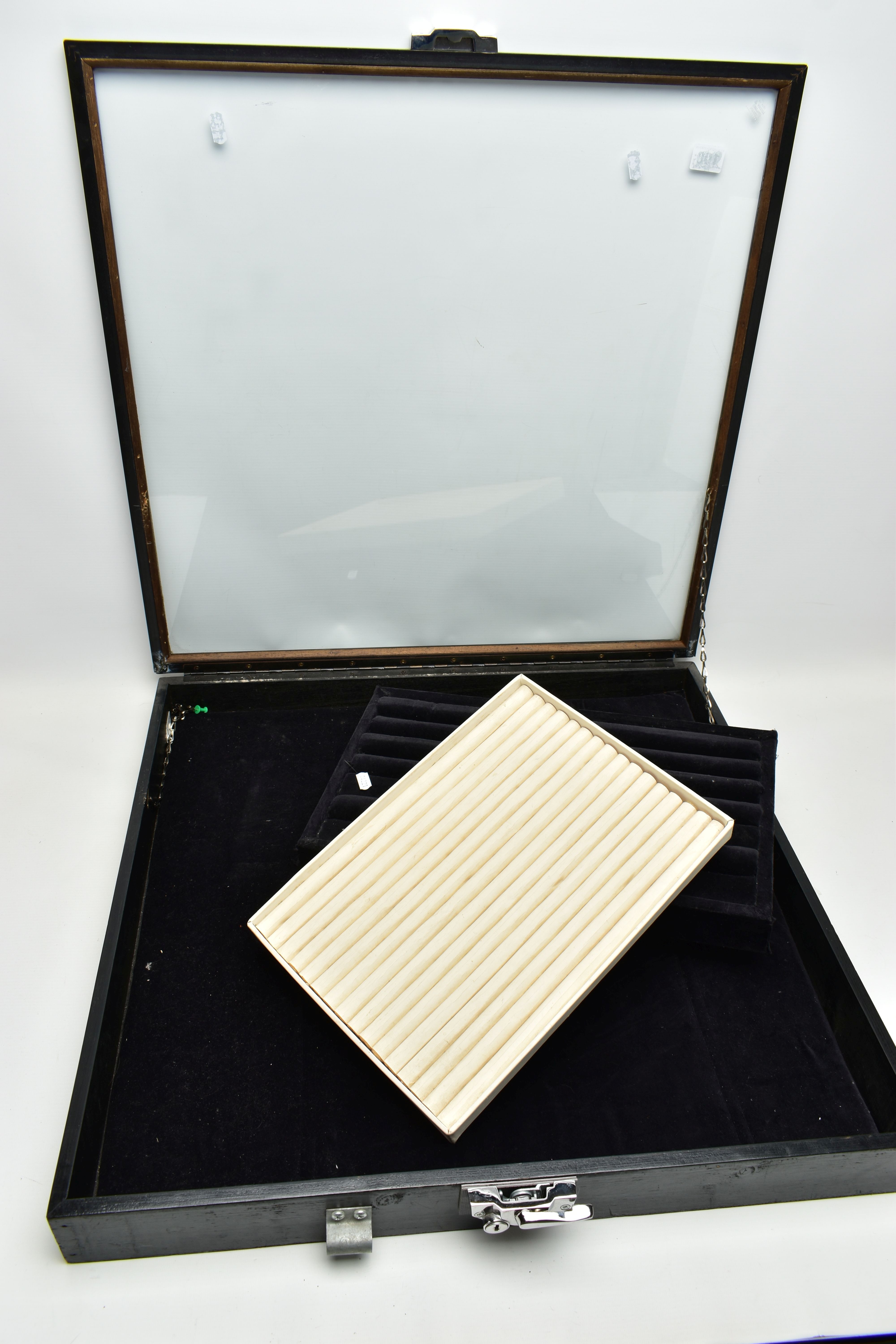 A LARGE JEWELLERY CASE AND TWO RING TRAYS, a square case fitted with a glass hinged lid and lock,