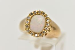 A YELLOW METAL OPAL AND DIAMOND CLUSTER RING, of an oval form, set with a cushion cut opal cabochon,