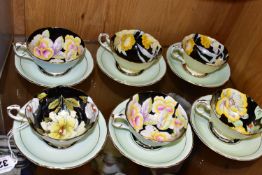 SIX PARAGON TEACUPS AND SAUCERS, the interiors of the cups decorated with flowers on a black ground,