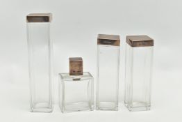A GEORGE VI SILVER LIDDED VANITY SET, comprised of three tall jars and a perfume bottle in an Art