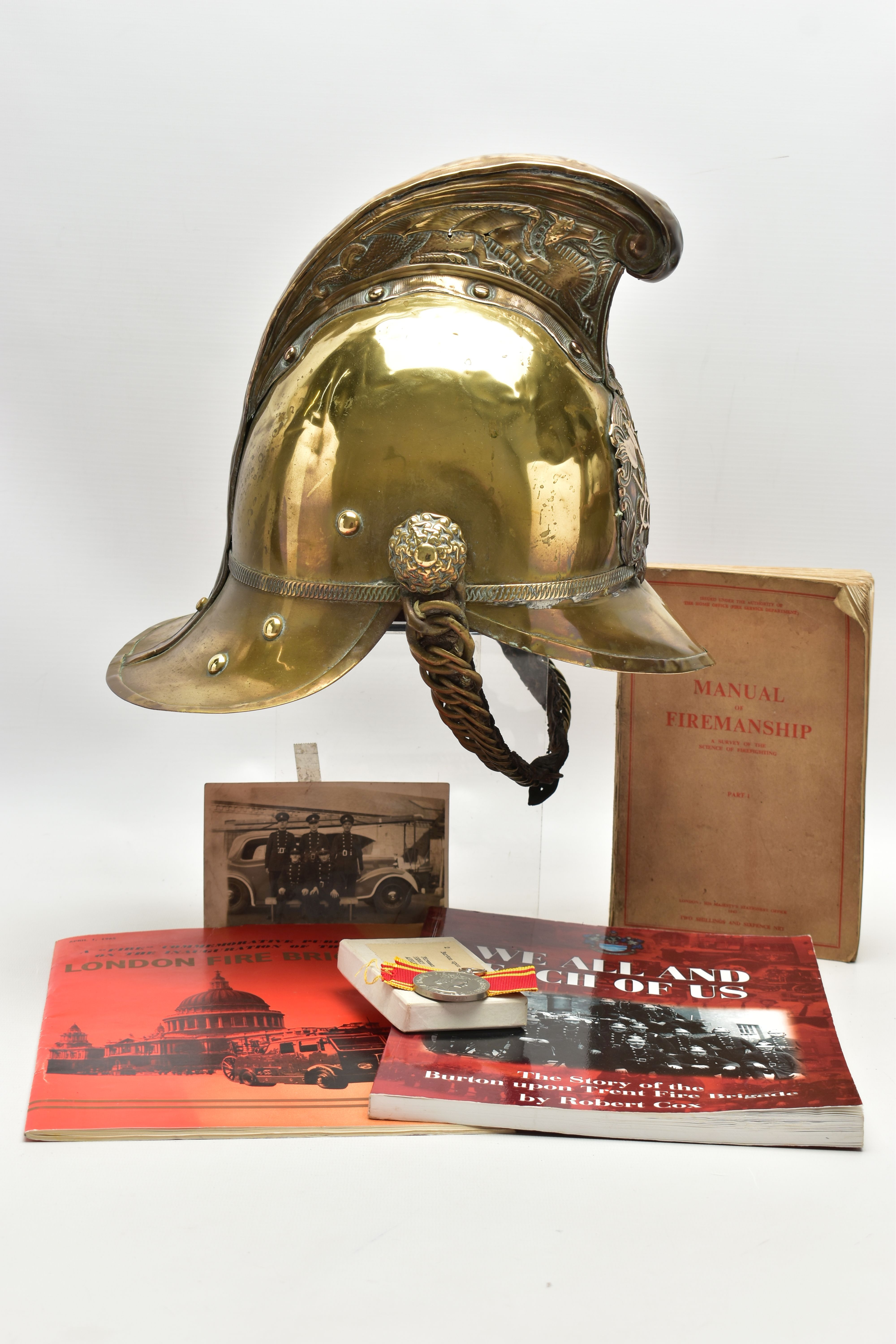 A VICTORIAN BRASS MERRYWEATHER TYPE FIREMAN'S HELMET, with a worn leather and brass chin strap and