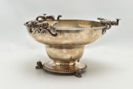 A GEORGE V SILVER PEDESTAL BOWL, with three cast handles, each formed of two serpents and two lion