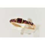 A YELLOW GOLD GEORGIAN GARNET RING, the rectangular cut garnet flanked to each side by three