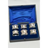 A CASED SET OF SIX GEORGE V SILVER NAPKIN RINGS, of circular form cast with scrolled rims, maker's