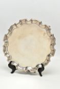 A GEORGE V SILVER SALVER OF CIRCULAR FORM WITH PIE CRUST RIM, plain surface, on three short cabriole
