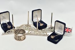 A SET OF FOUR LATE VICTORIAN SILVER MENU HOLDERS, with pierced and cast scrolled design, maker Henry