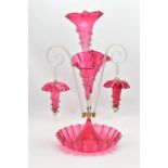 A VICTORIAN CRANBERRY AND CLEAR GLASS EPERGNE, the central trumpet with trailing decoration,