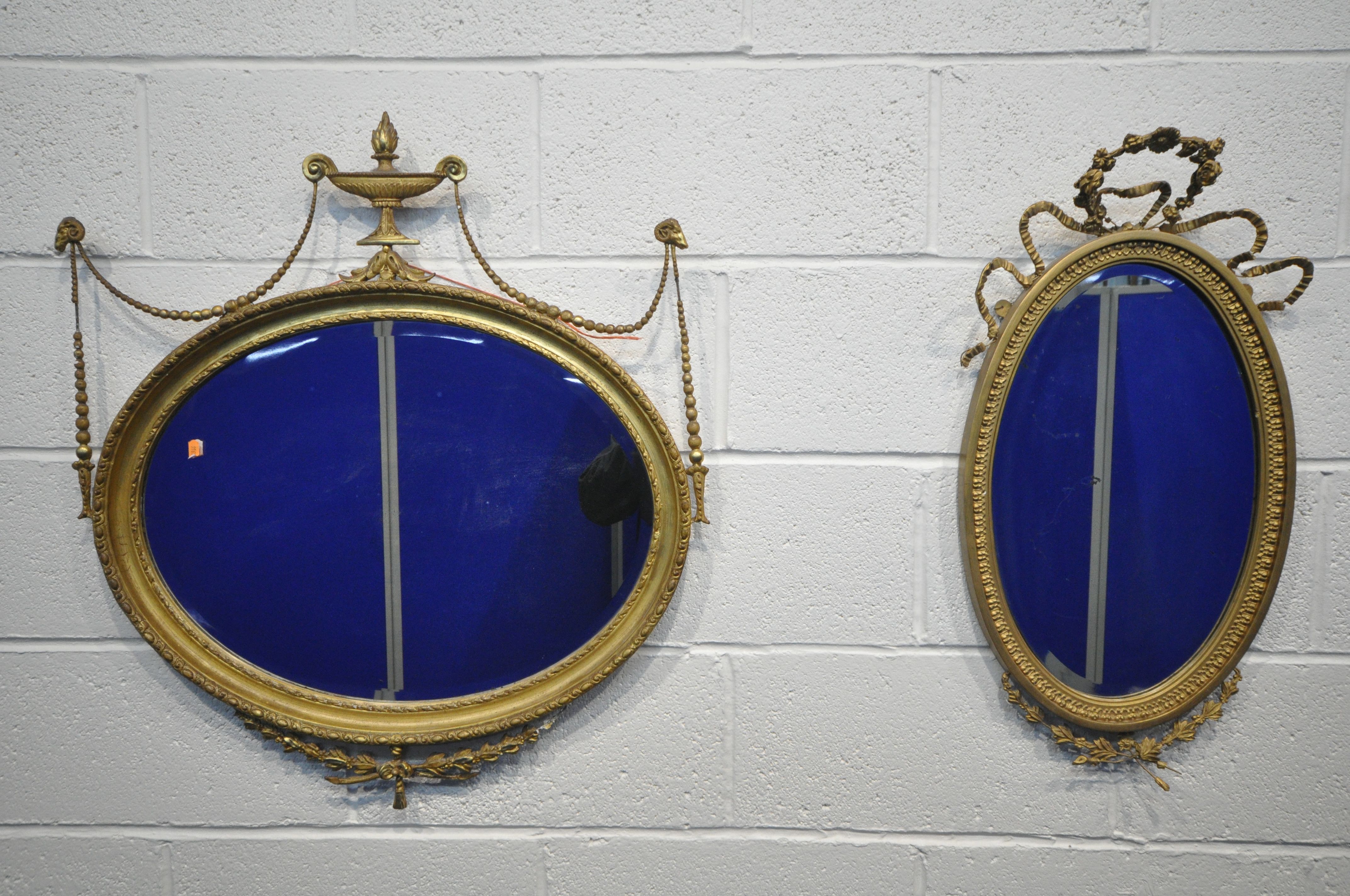 A NEOCLASSICAL GILTWOOD OVAL WALL MIRROR, 19th century, bevelled edge plate, with central surmount