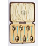 A CASED SET OF SIX GEORGE V SILVER GILT AND ENAMEL COFFEE SPOONS, the handles engine turned and
