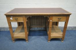 AN ARTS AND CRAFTS LIMED OAK PEDESTAL DESK, with a burgundy leatherette writing surface, inlaid with