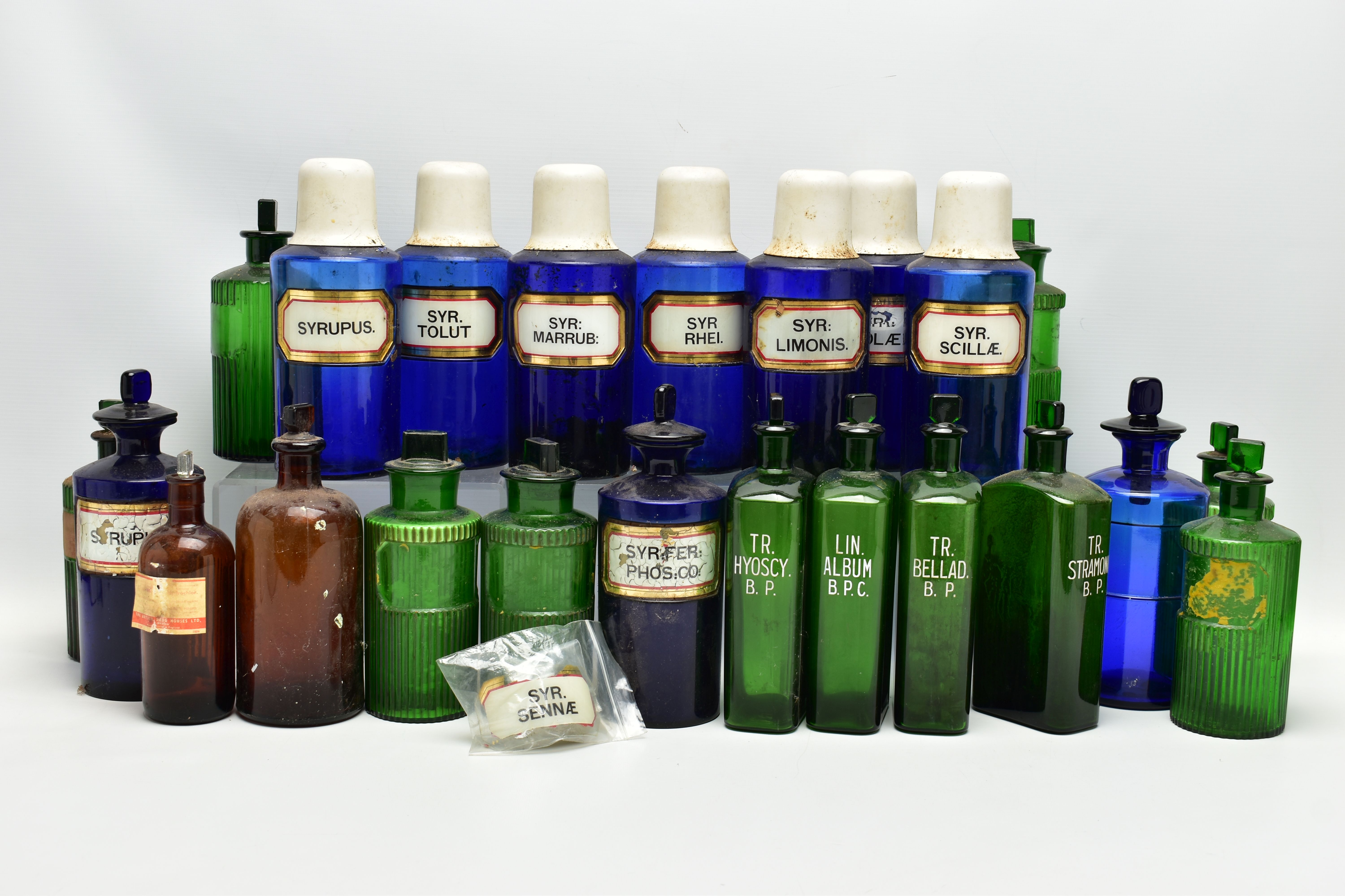 A COLLECTION OF TWENTY THREE COLOURED GLASS PHARMACY BOTTLES, comprising ten blue cylindrical