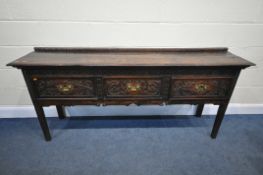 A GEORGE III AND LATER CARVED OAK DRESSER BASE, the plank top in front of a raised back and three