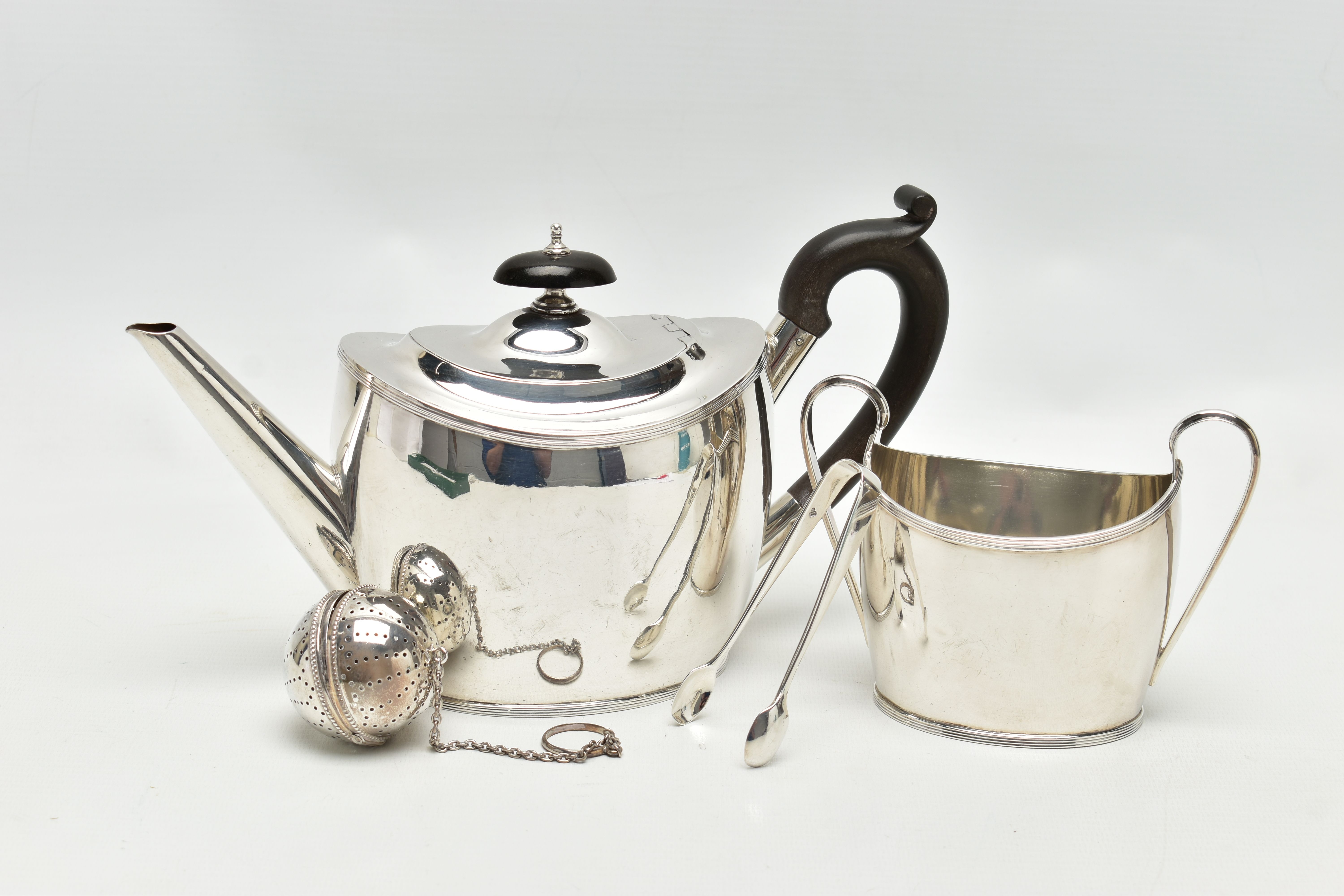 A GEORGE V SILVER TWO PIECE TEA SET OF OVAL FORM, comprising teapot and sugar bowl with reeded rims,