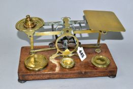 A SET OF BRASS POSTAL SCALES WITH A COMPLETE SET OF BRASS WEIGHTS, mounted to a wooden plinth