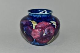 A SMALL MOORCROFT POTTERY BALUSTER VASE, decorated with tube lined purple Pansy pattern on a dark