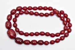 A GRADUATING BAKELITE BEAD NECKLACE, oval cherry amber colour beads, graduating in size, largest