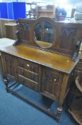 AN EARLY TO MID 20TH CENTURY OAK MIRRORBACK SIDEBOARD, with a circular mirror back, on a base with