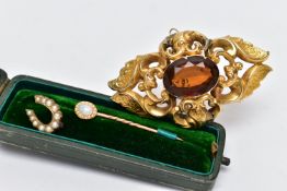 A LARGE YELLOW METAL BROOCH AND A STICK PIN, the brooch of a marquise form, decorated with scrolls