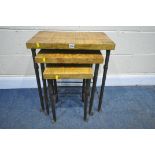 A SOLID OAK TOP NEST OF THREE TABLES, with wrought iron legs and supports, largest width 55cm x