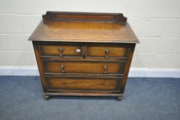 A SOLID OAK CHEST OF TWO SHORT AND TWO LONG DRAWERS, with a raised back, on turned legs and casters,