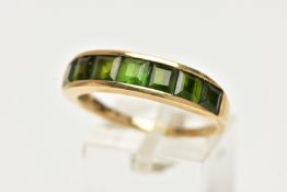 A 9CT GOLD GEM SET RING, designed with a row of channel set, graduating square cut green