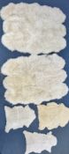 TWO LARGE FAUX SHEEP SKIN RUGS, 185cm x 151cm, and three small sheep skin rugs (5)