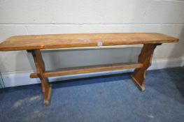 A BEECH TRESTLE BENCH, with a stretcher, length 134cm x depth 25cm x height 56cm (condition:-worn