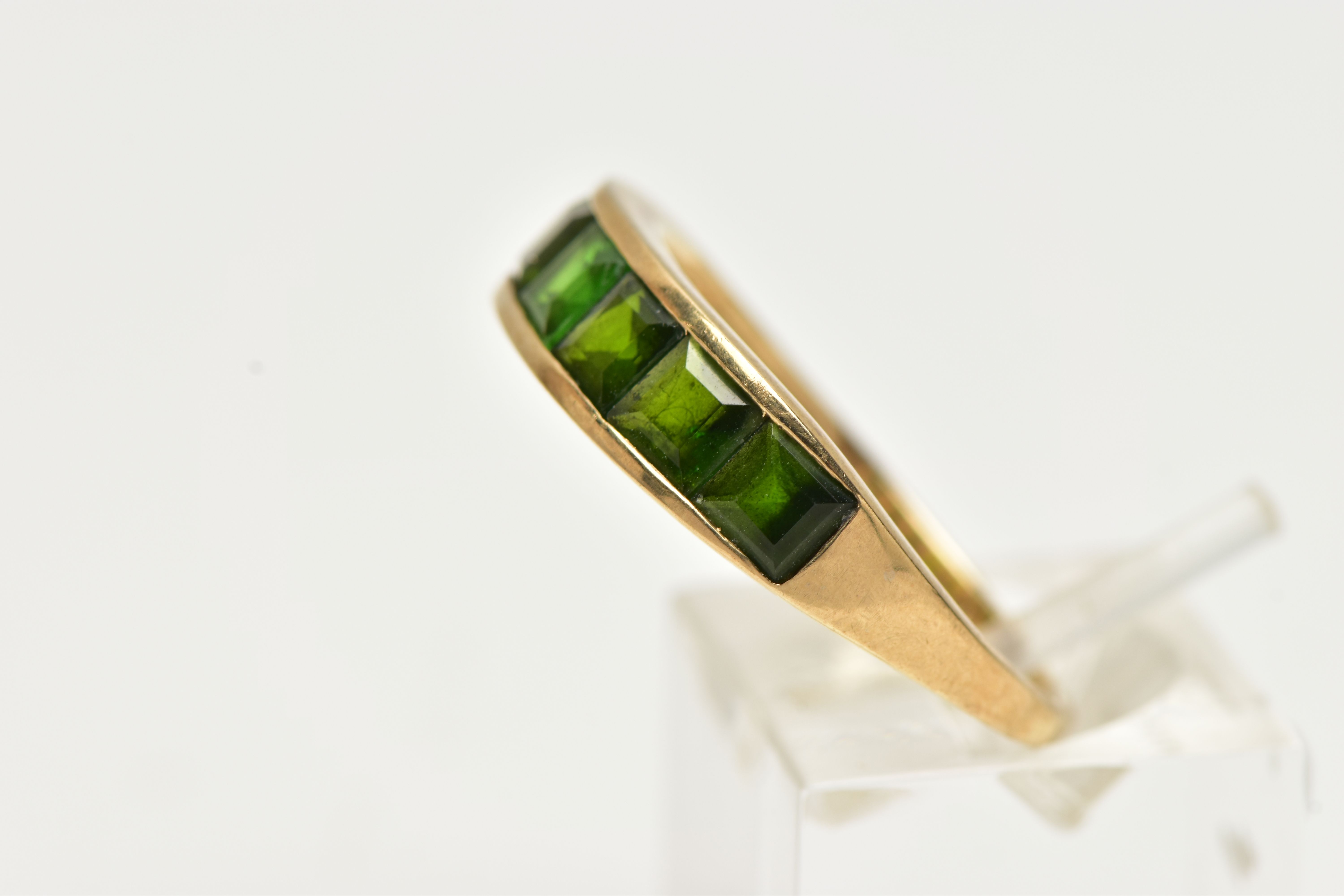 A 9CT GOLD GEM SET RING, designed with a row of channel set, graduating square cut green - Image 2 of 4