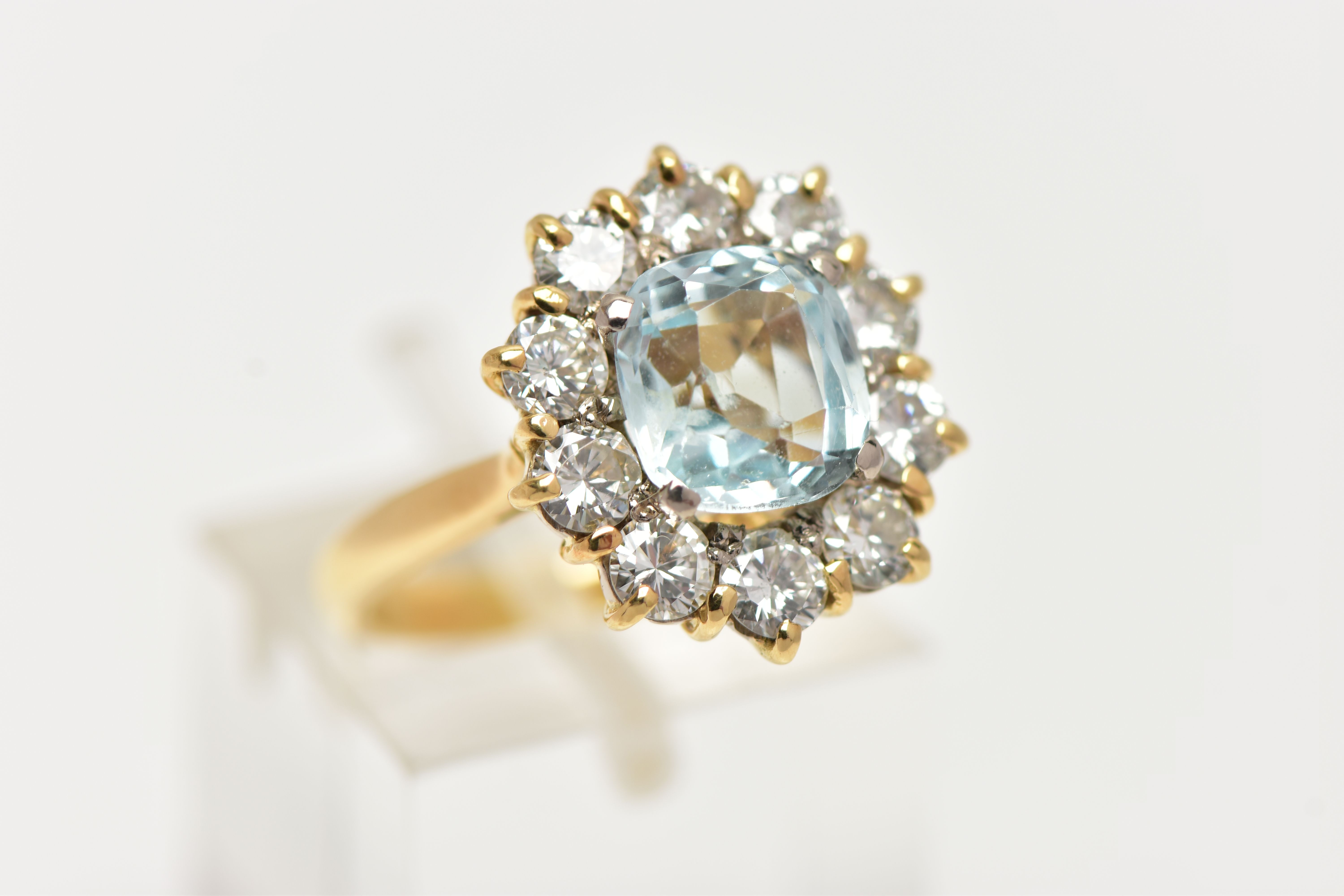 A YELLOW METAL AQUAMARINE AND DIAMOND CLUSTER RING, centring on a four claw set, cushion cut - Image 4 of 7