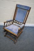 AN EDWARDIAN WALNUT AMERICAN ROCKING CHAIR (condition:-surface scratches)