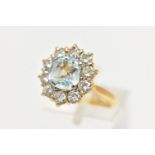 A YELLOW METAL AQUAMARINE AND DIAMOND CLUSTER RING, centring on a four claw set, cushion cut