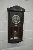 AN EARLY TO MID 20TH CENTURY OAK WALL CLOCK, with winding key and pendulum (condition - some